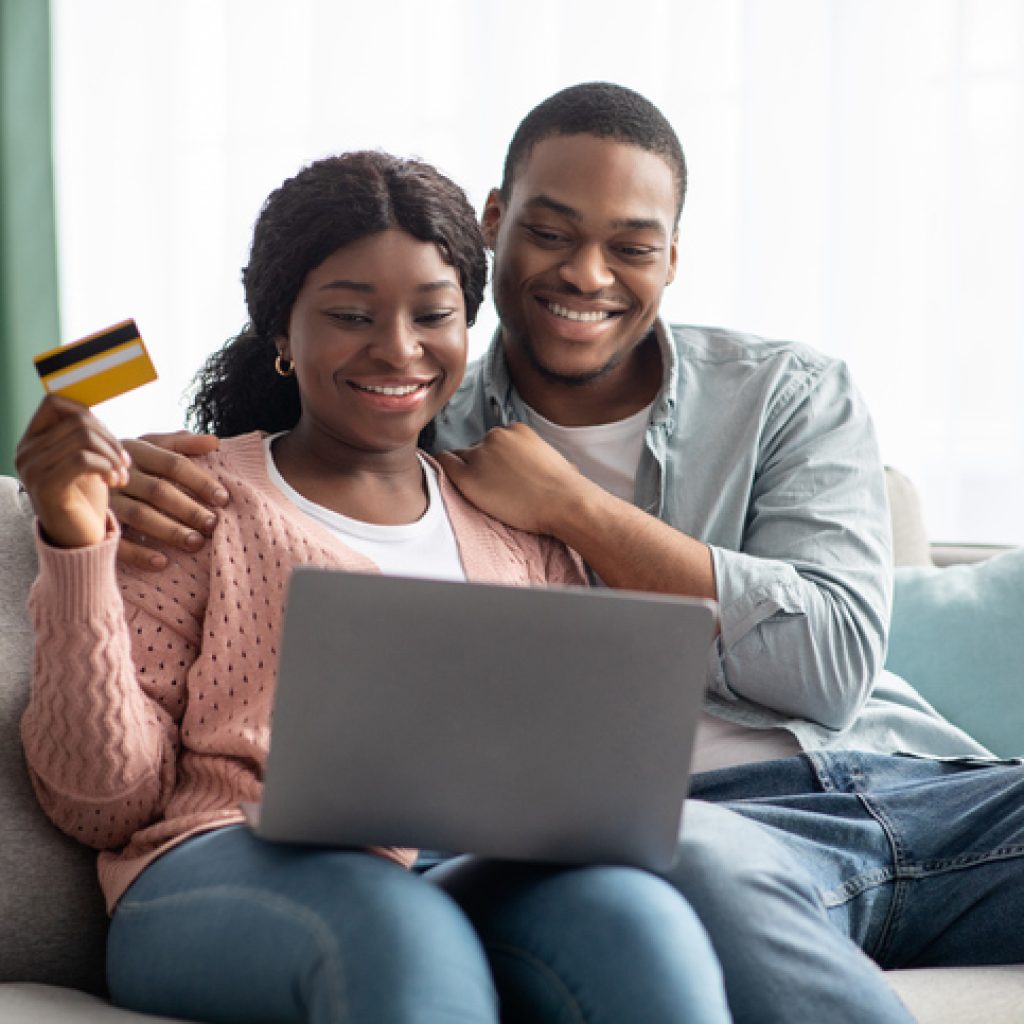 Happy african american couple with credit card and laptop assistance d'achat
